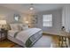 Bright bedroom featuring a ceiling fan and a queen bed with decorative pillows at 1069 Sedgefield Rd, Charlotte, NC 28209