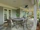 Comfortable seating under a covered patio with a ceiling fan and stone flooring for relaxing outdoors at 1069 Sedgefield Rd, Charlotte, NC 28209