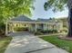 An inviting home with a covered carport and quaint outdoor seating area nestled in a lush, green landscape at 1069 Sedgefield Rd, Charlotte, NC 28209