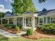 Inviting home with a charming covered porch, featuring classic columns and professionally landscaped surroundings at 1069 Sedgefield Rd, Charlotte, NC 28209