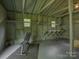 Inside of garage with a gym area, including bench, dumbbells and rubber flooring at 1069 Sedgefield Rd, Charlotte, NC 28209