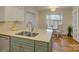 Kitchen island with a double sink and view of a bright breakfast nook at 1069 Sedgefield Rd, Charlotte, NC 28209