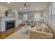 Bright living room with a fireplace, modern furnishings, and abundant natural light streaming through shuttered windows at 1069 Sedgefield Rd, Charlotte, NC 28209