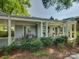 Covered patio area with an outdoor dining set, perfect for entertaining in a serene, landscaped setting at 1069 Sedgefield Rd, Charlotte, NC 28209