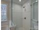 Clean glass-enclosed shower with tile surround and glass block window at 1069 Sedgefield Rd, Charlotte, NC 28209