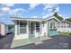 Charming home with teal and white exterior, decorative accents, and delightful curb appeal under a bright blue sky at 125 Maple St, New London, NC 28127