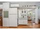 Bright kitchen featuring white cabinets, a refrigerator, and wood floors, leading into a comfortable living area at 125 Maple St, New London, NC 28127