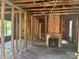 Unfinished living room featuring exposed wood framing and brick fireplace at 126 N Kendall St, Norwood, NC 28128