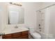 Well-lit bathroom with a tub/shower combo, wood vanity, large mirror, and toilet at 12792 Clydesdale Dr, Midland, NC 28107
