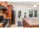 Bright kitchen featuring stainless steel appliances, wood cabinets, and access to the backyard patio at 12792 Clydesdale Dr, Midland, NC 28107