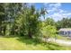 Sprawling backyard with vibrant green grass, mature trees, and a partial view of the home at 128 Paul Snipes Rd, Lancaster, SC 29720