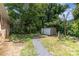 Overgrown backyard featuring an old shed with surrounding lush trees and ground cover at 128 Paul Snipes Rd, Lancaster, SC 29720