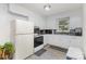 Well-lit kitchen featuring white cabinetry and appliances, complemented by grey vinyl floors at 128 Paul Snipes Rd, Lancaster, SC 29720