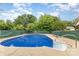 Backyard pool surrounded by a concrete patio, green fence, and trees under a blue sky with clouds at 128 Paul Snipes Rd, Lancaster, SC 29720