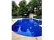 An in-ground pool surrounded by fencing and mature trees with seating area and shed at 128 Paul Snipes Rd, Lancaster, SC 29720