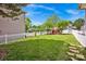 Lush green backyard with a well-manicured lawn, white picket fence, and comfortable seating area at 14940 Carbert Ln, Huntersville, NC 28078