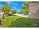 Spacious backyard featuring a well-maintained lawn, charming white picket fence, and comfortable red outdoor chairs at 14940 Carbert Ln, Huntersville, NC 28078