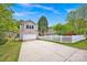 Charming home featuring a spacious driveway leading to an attached garage, bordered by a classic white picket fence at 14940 Carbert Ln, Huntersville, NC 28078