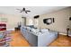 Large living room with hardwood floors, neutral walls, ceiling fan, TV, and gray sectional at 14940 Carbert Ln, Huntersville, NC 28078
