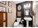 Stylish powder room features wallpaper, pedestal sink, and modern lighting at 14940 Carbert Ln, Huntersville, NC 28078
