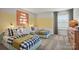 Charming bedroom featuring two twin beds with blue and white bedding, and colorful wall decor at 15008 Meadows Hunt Ln # 156, Huntersville, NC 28078