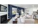 Stylish living room with a fireplace, blue accent wall, and an adjacent dining area at 151 Rustling Waters Dr, Mooresville, NC 28117