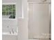 Bright bathroom featuring a large tub with jets and shower with glass doors at 15108 Castlebridge Ln, Matthews, NC 28104