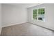 Bright, carpeted bedroom with a large window offering an outdoor view at 15108 Castlebridge Ln, Matthews, NC 28104