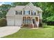 Charming two-story home features a well-manicured lawn, two-car garage, and inviting front porch at 15108 Castlebridge Ln, Matthews, NC 28104