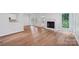 Spacious living area with fireplace, hardwood flooring, and a seamless transition to the kitchen at 15108 Castlebridge Ln, Matthews, NC 28104