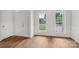 Light and airy living room features detailed wall trim, hardwood floors, and large windows at 15108 Castlebridge Ln, Matthews, NC 28104