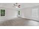 Spacious main bedroom with plush carpet, a ceiling fan, and natural light from the many windows at 15108 Castlebridge Ln, Matthews, NC 28104