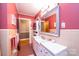 The retro bathroom features dual sinks, a large mirror, and a stackable washer and dryer for convenience at 1602 Brentwood Dr, Newton, NC 28658