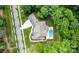 Aerial view of a home showing the roof, pool, well-manicured landscaping, and driveway with surrounding green trees at 17416 Gillican Overlook Rd, Davidson, NC 28036