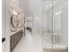 Open bathroom with glass enclosed shower, soaking tub and double vanity at 17416 Gillican Overlook Rd, Davidson, NC 28036