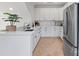 Modern white kitchen featuring quartz countertops, stainless steel appliances, and hardwood floors at 17416 Gillican Overlook Rd, Davidson, NC 28036