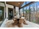 Inviting outdoor kitchen featuring a built-in grill, dining area, and expansive views of nature through large windows at 17416 Gillican Overlook Rd, Davidson, NC 28036