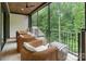 Covered patio with woven chairs and striped ottomans providing a relaxing outdoor space with views of trees at 17416 Gillican Overlook Rd, Davidson, NC 28036