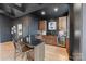 Stylish wet bar with custom cabinetry, granite countertops, and modern barstools, perfect for entertaining guests at 17416 Gillican Overlook Rd, Davidson, NC 28036