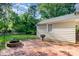 Backyard brick patio, fire pit, and barbecue area; string lights are hung among the mature trees at 1809 The Plaza None, Charlotte, NC 28205