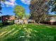 Wide backyard with a lush lawn, detached structure, and mature trees creating a private and inviting outdoor space at 1809 The Plaza None, Charlotte, NC 28205