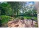 Brick patio with fire pit, lush green lawn, and mature trees create an inviting outdoor space at 1809 The Plaza None, Charlotte, NC 28205
