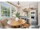 Bright dining area with a wooden table, modern lighting, and large windows at 1809 The Plaza None, Charlotte, NC 28205