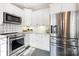 Well-lit kitchen boasts stainless steel appliances, white cabinetry, and decorative backsplash at 1809 The Plaza None, Charlotte, NC 28205