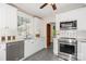 Well-lit kitchen boasts stainless steel appliances, white cabinetry, marble countertops, and stone floors at 1809 The Plaza None, Charlotte, NC 28205