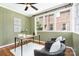 Bright sunroom with large windows, wooden floors, stylish decor, and a ceiling fan at 1809 The Plaza None, Charlotte, NC 28205