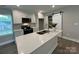 This kitchen has shaker cabinets, an island with a stainless sink, and a sliding barn door to a pantry at 2012 Crown Point Dr # A, Albemarle, NC 28001