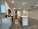 Bright kitchen features an island with a stainless sink and a decorative rug on the wood floor at 2012 Crown Point Dr # A, Albemarle, NC 28001