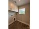 Laundry room with window, wood floors, and cabinets at 2012 Crown Point Dr # A, Albemarle, NC 28001
