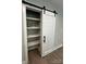 Walk-in pantry with a sliding barn door and shelves lined with glass storage jars at 2012 Crown Point Dr # A, Albemarle, NC 28001
